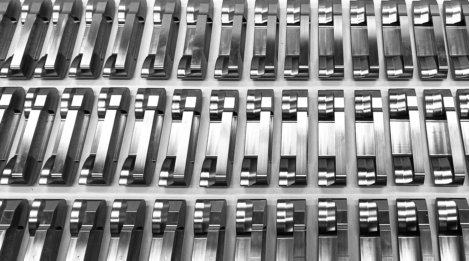 Rows of machined putter heads awaiting finishing